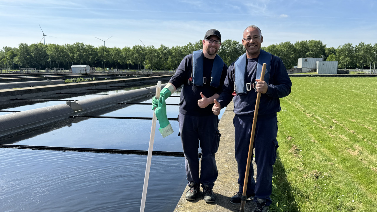 Zwei Mitarbeiter auf der Kläranlage am Becker der biologischen Reinigung