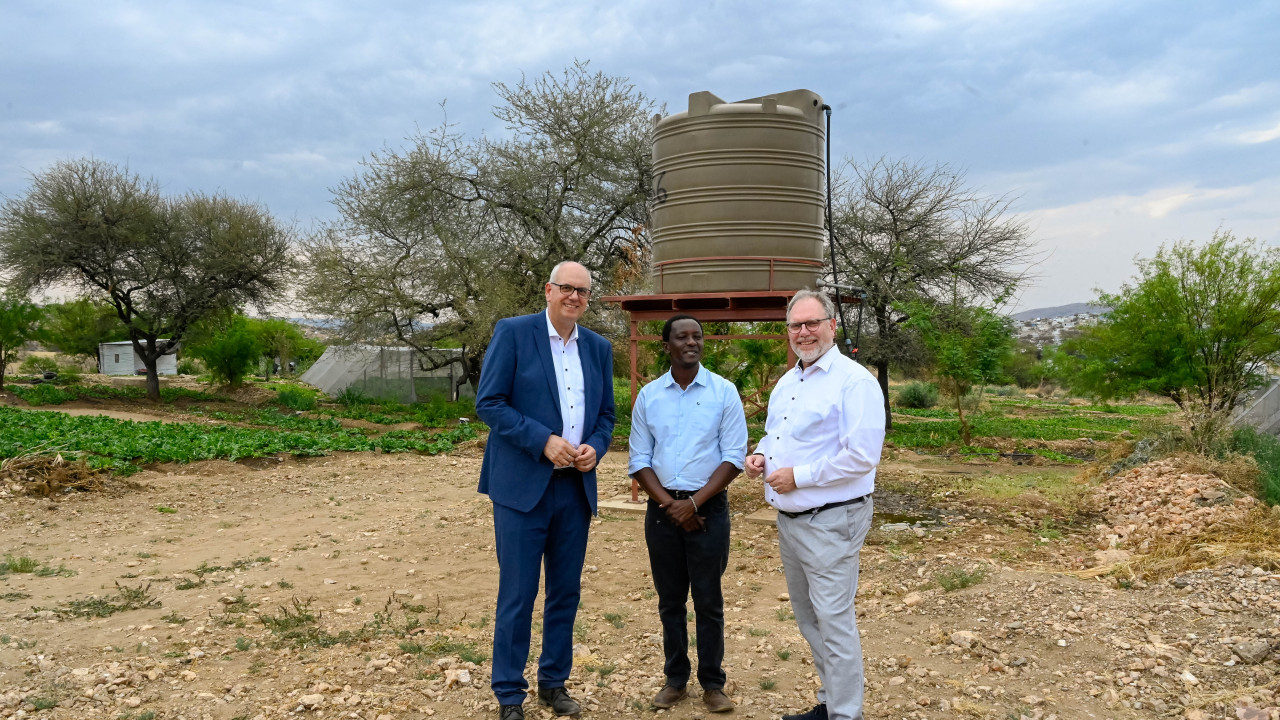 Bürgermeister Andreas Bovenschulte, Leiter der Okukuna-Farm James Kalundu und kaufmännischer Geschäftsführer hanseWasser Ekkehart Siering stehen auf der Farm