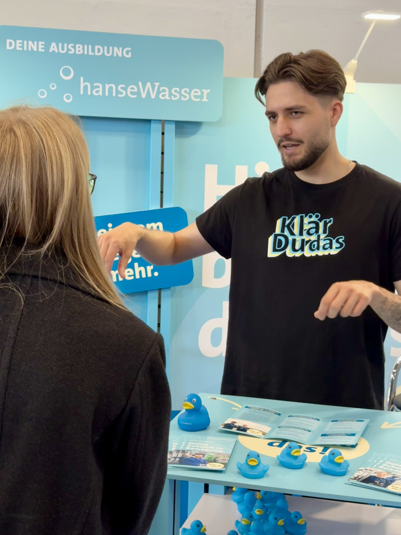 Eine Person erklärt einer anderen Person etwas an einem Stehtisch