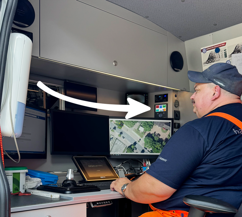 Person schaut auf drei Monitore.