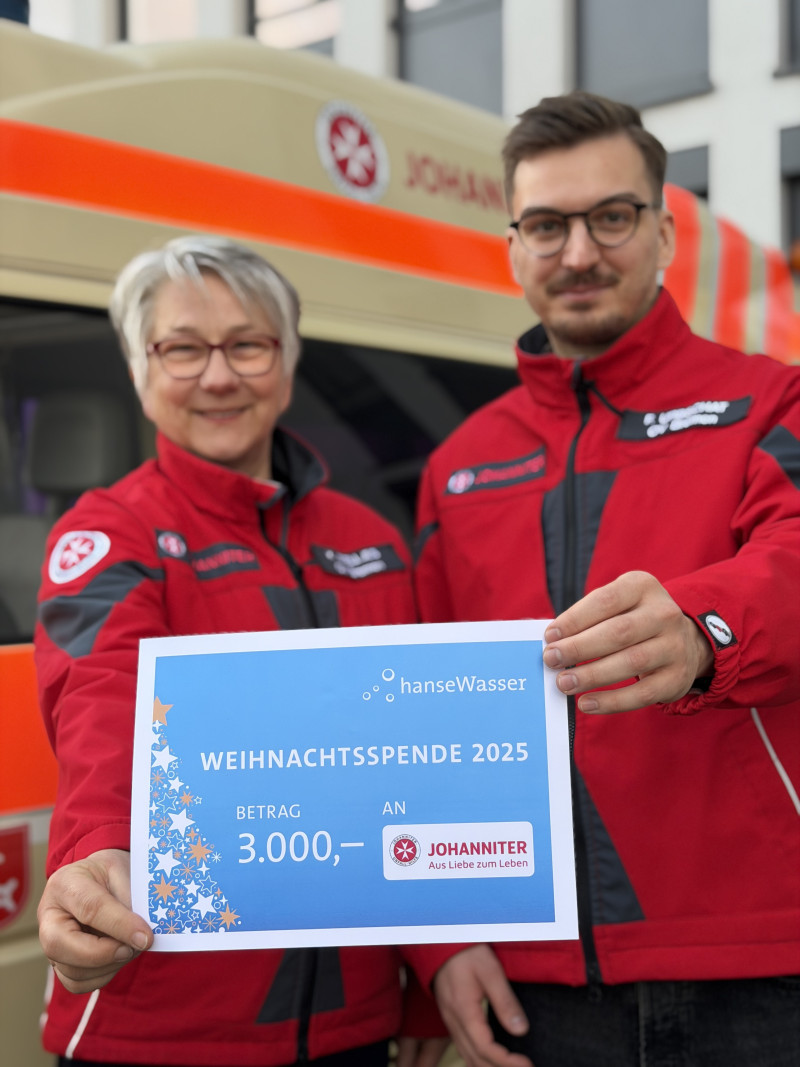 Zwei Personen halten den Spendenscheck.